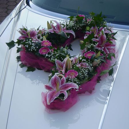Ein Blumenstrauß mit pinken Blumen auf einem weißen Auto