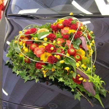 Ein Blumenstrauß mit bunten Blumen auf einem schwarzen Auto