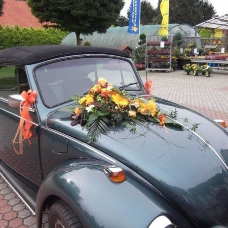 Ein Blumenstrauß mit bunten Blumen auf einem schwarzen Auto