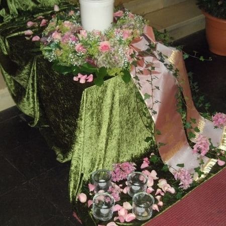Eine Kerze mit einem Blumenkranz auf einem Sarg