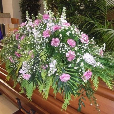 Rosa Blumen auf einem Sarg
