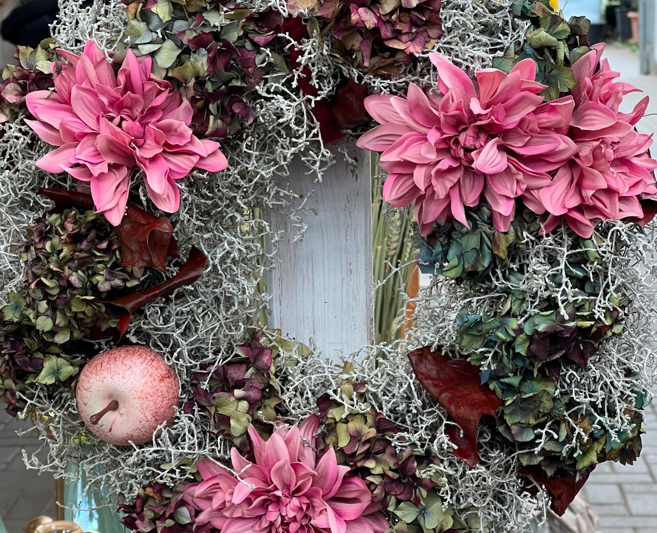 Ein Blumenkranz mit einem Apfel und rosa Blumen